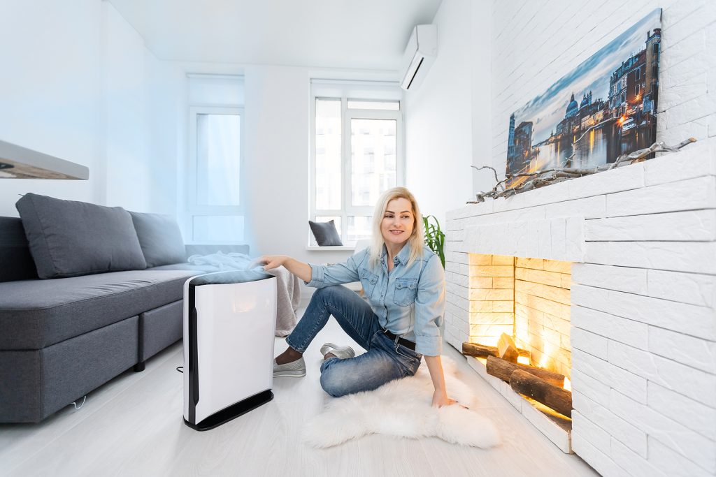 woman turning on and using the modern air purifier in the living room
