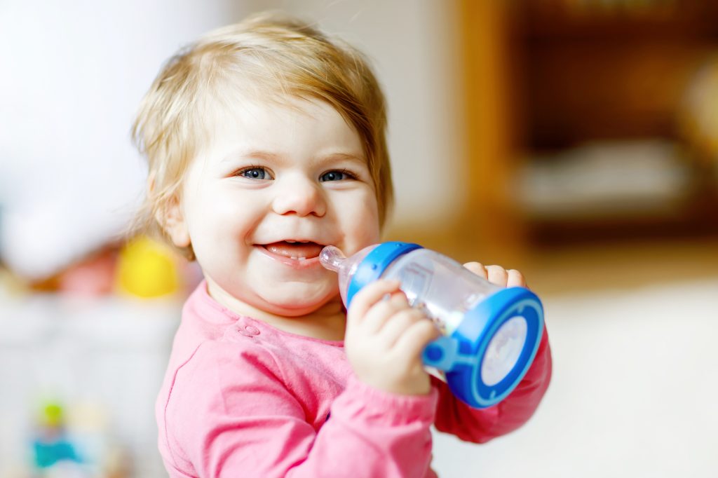 Cute Adorable Baby Girl Holding Nursing Bottle