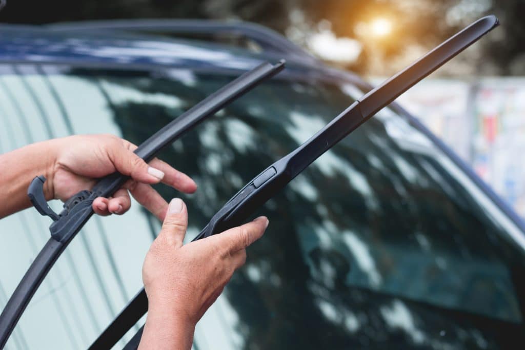 Mechanic replace windshield wipers on car. Replacing wiper blades Change cars wiper blades. Technician Man changing windshield wipers blades on car.