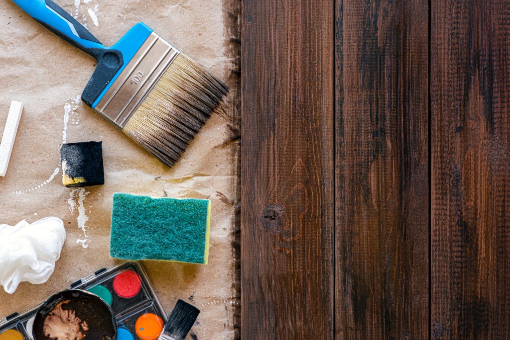 Simple tools for wood staining and wood painting at home in a flat lay view with ample space for copy and text