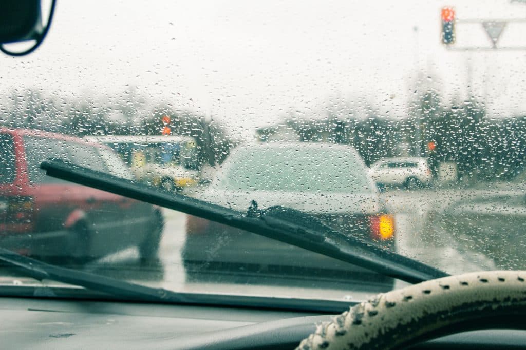 Windshield wipers from inside of car, season rain. the front and background are blurred with a bokeh effect